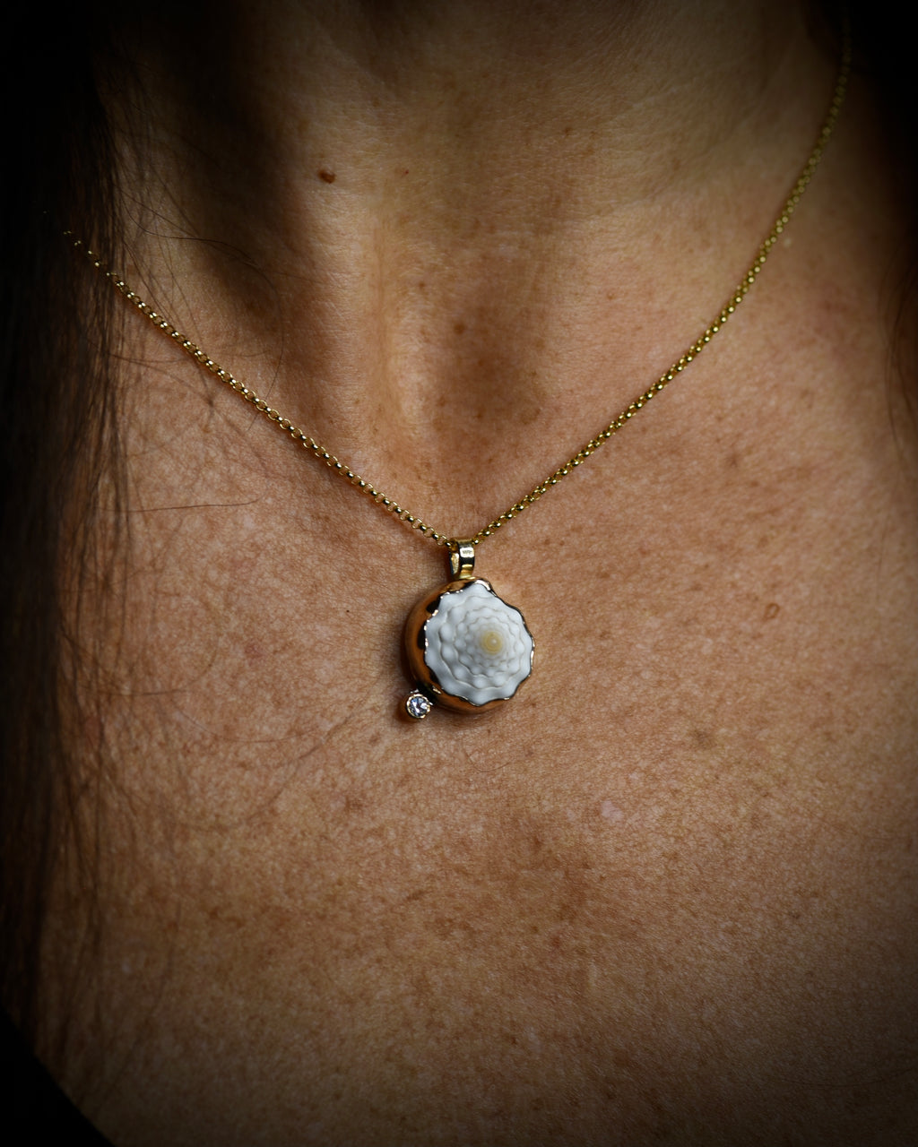 Petite Puka Dot necklace with pale cream Hawaiian puka shell and topaz accent worn on an 18-inch gold-filled chain
