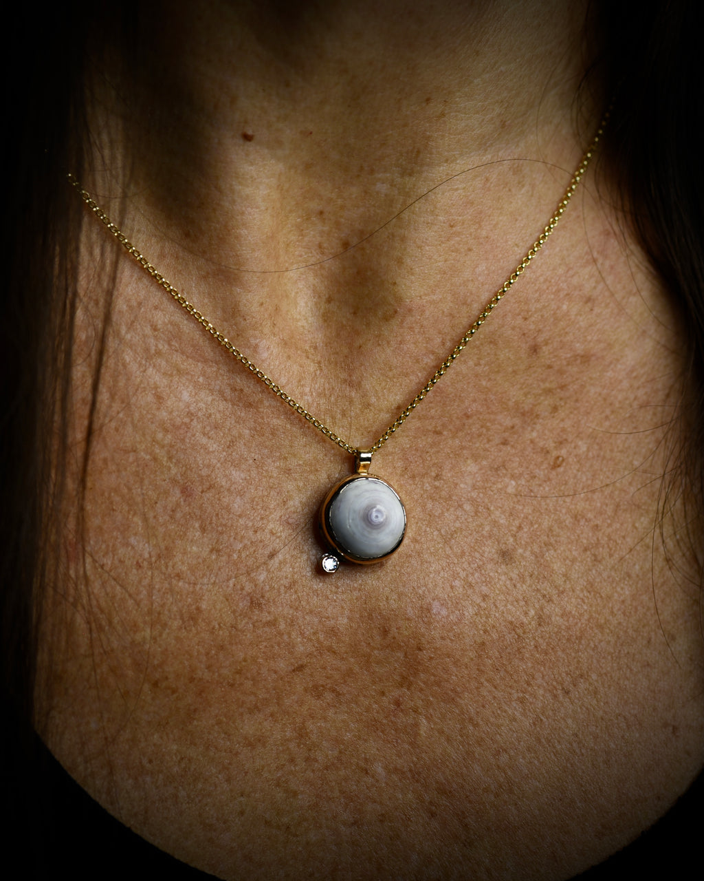 Petite Puka Dot necklace with pale purple Hawaiian puka shell and topaz accent worn on an 18-inch gold-filled chain
