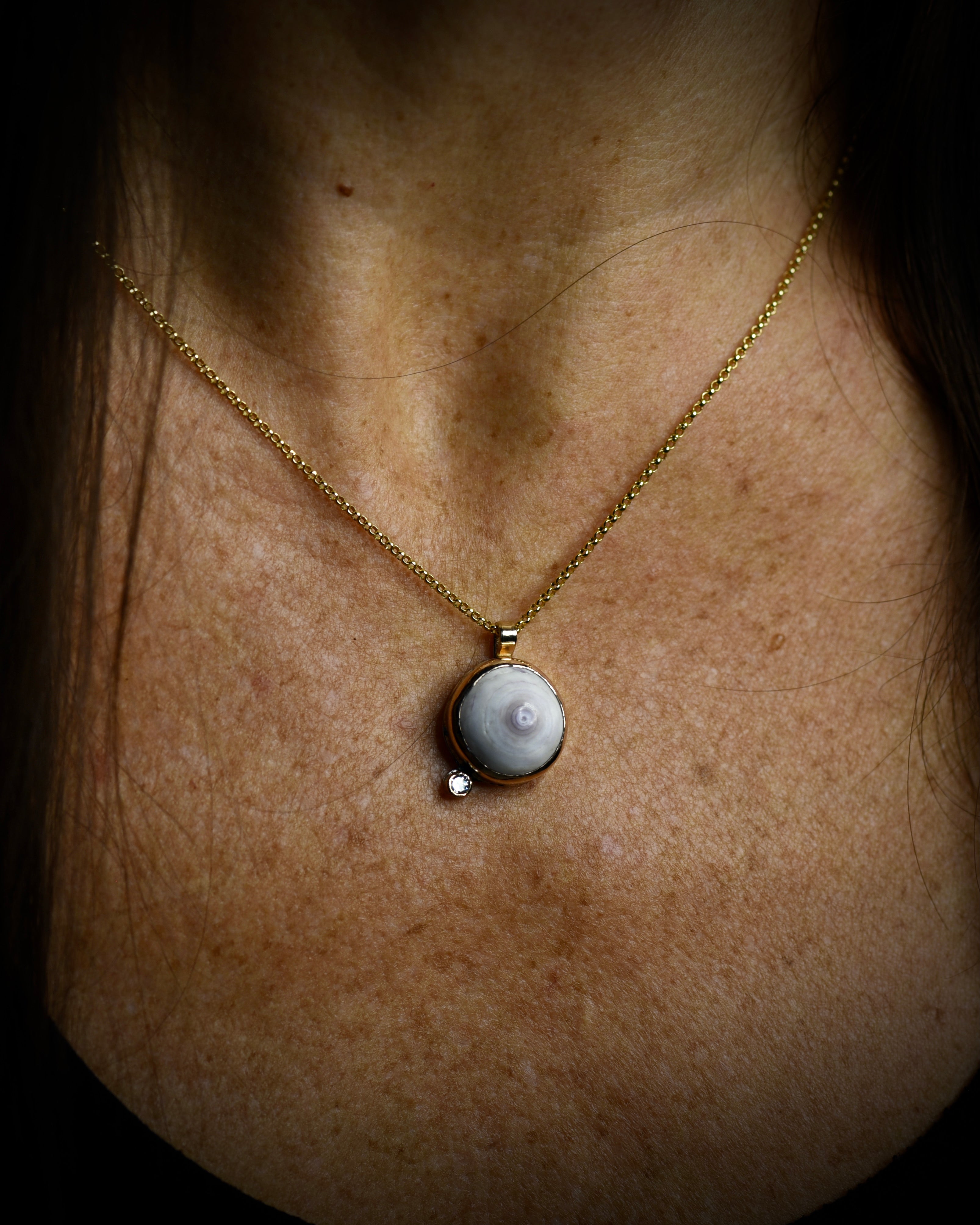 Petite Puka Dot necklace with pale purple Hawaiian puka shell and topaz accent worn on an 18-inch gold-filled chain
