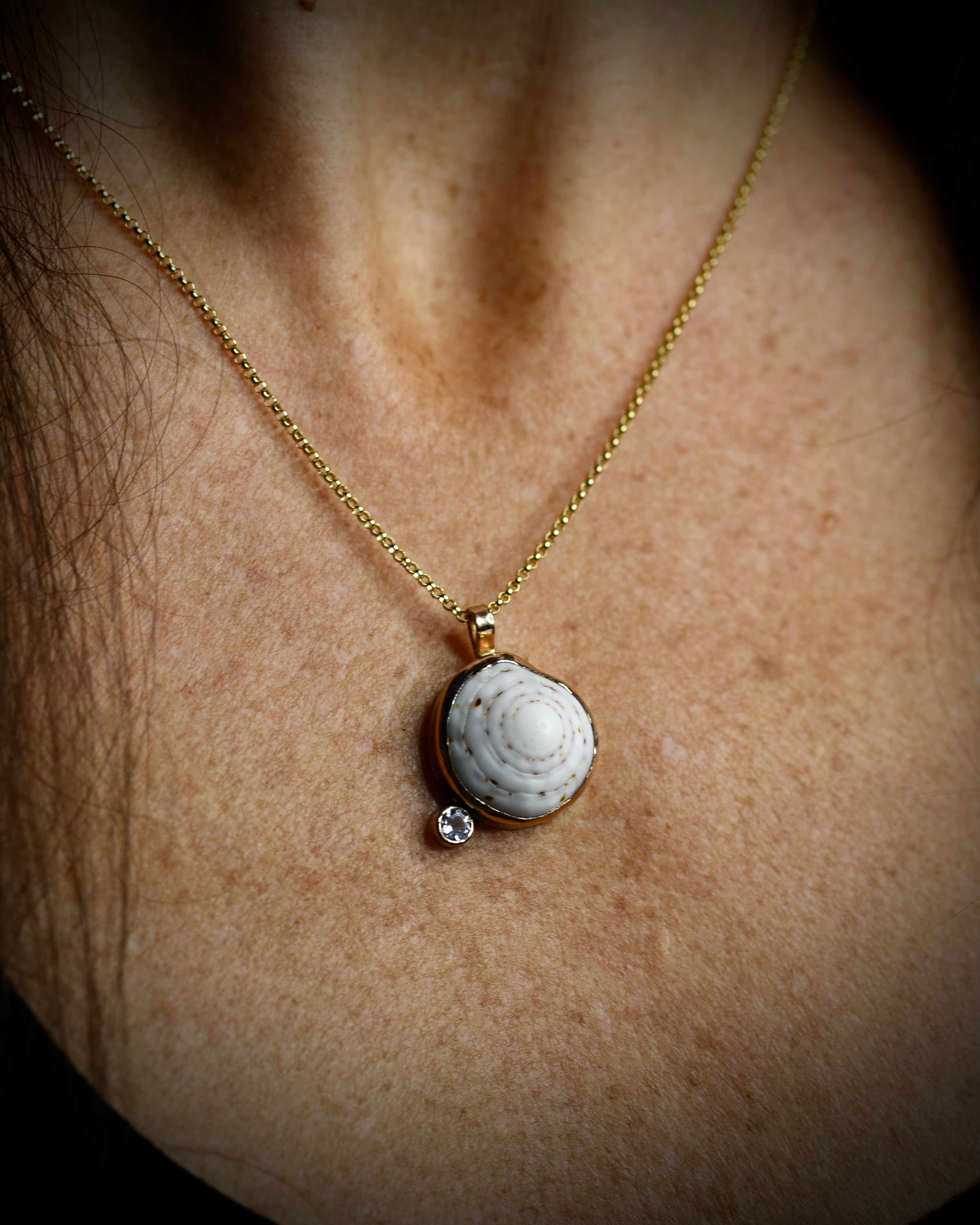 Midi Puka Dot necklace with a white Hawaiian puka shell and topaz accent worn on an 18-inch gold-filled chain
