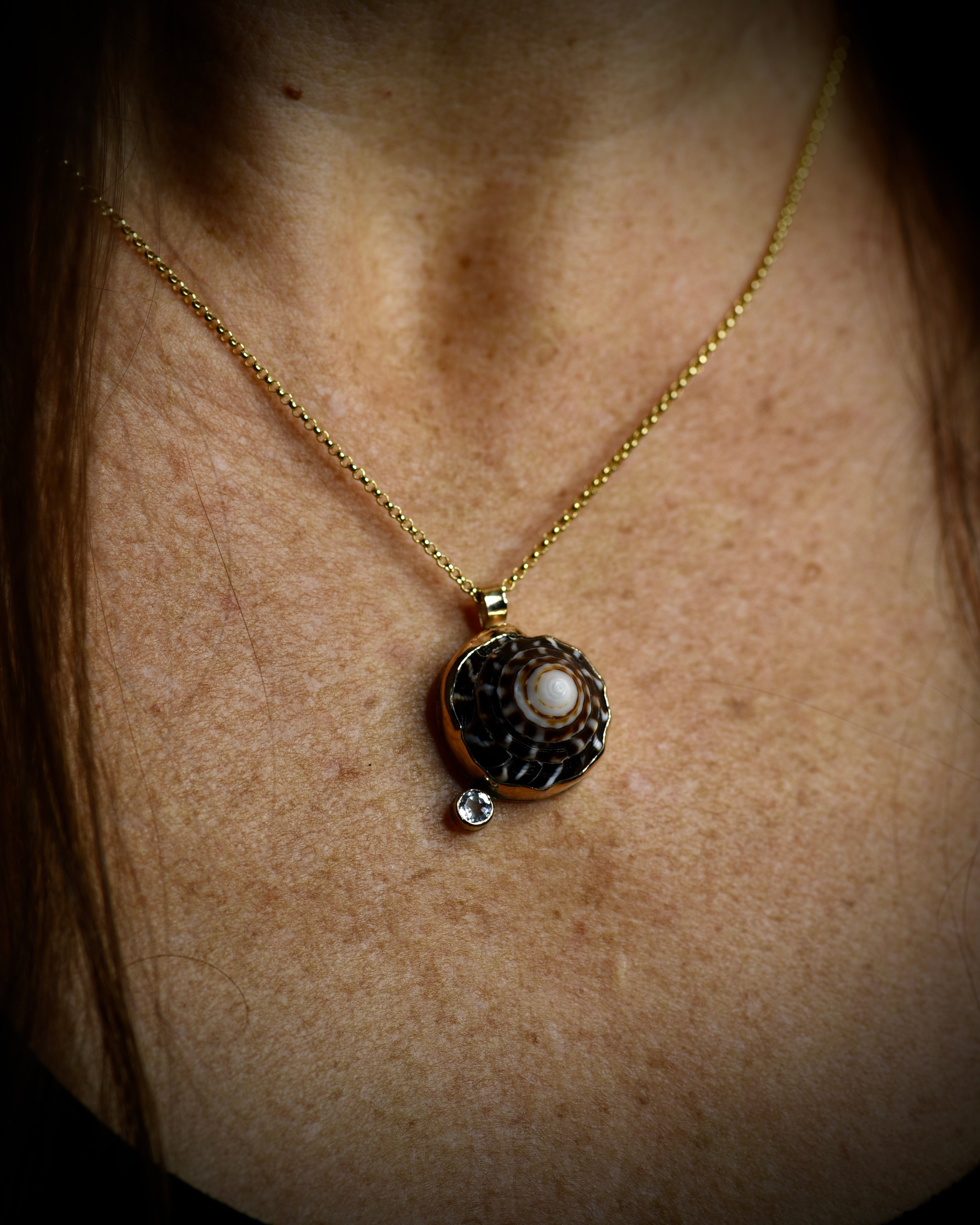 Midi Puka Dot necklace with dark brown and cream Hawaiian puka shell and topaz accent worn on an 18-inch gold-filled chain
