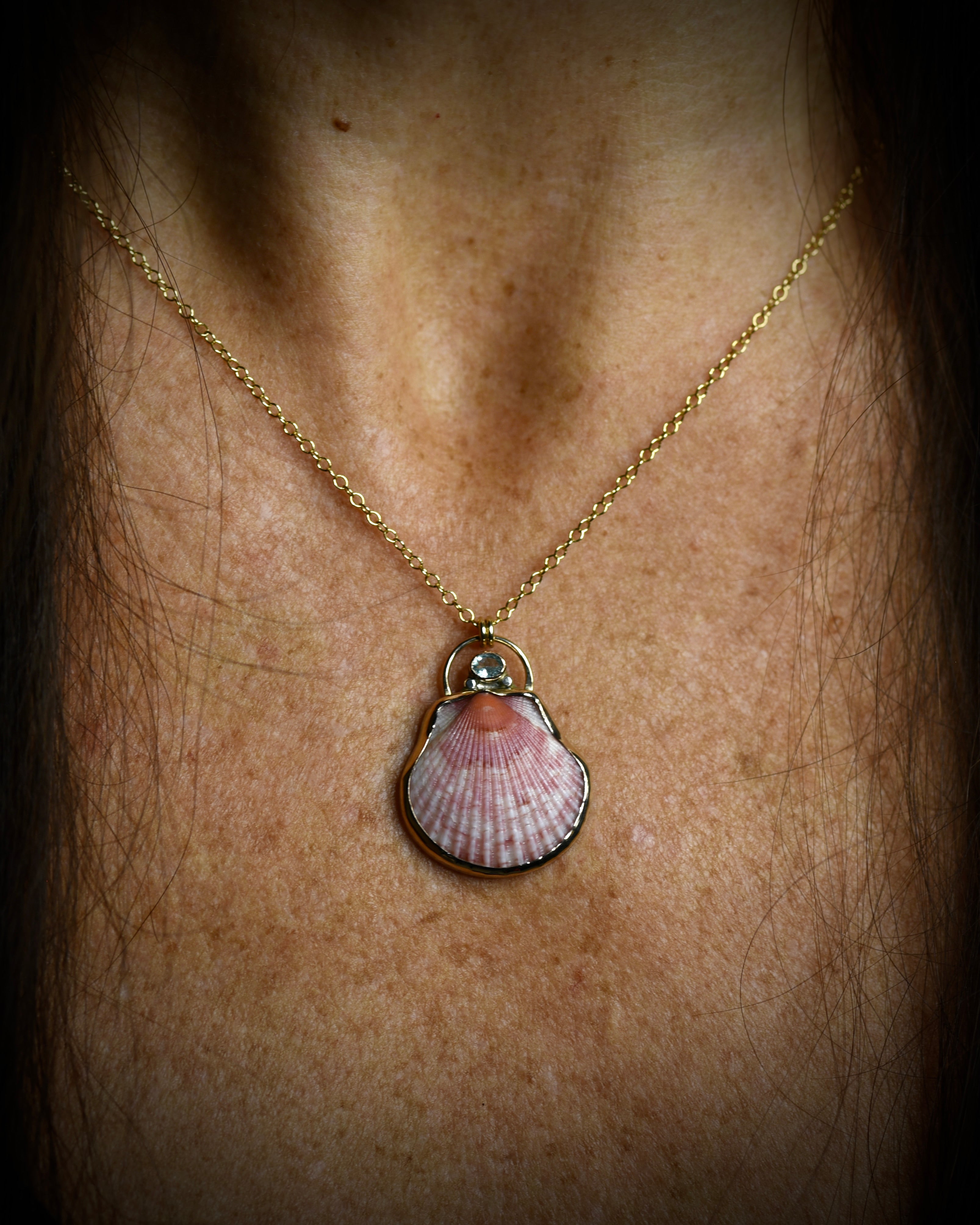 Lavender pink scallop shell pendant necklace worn on a delicate chain
