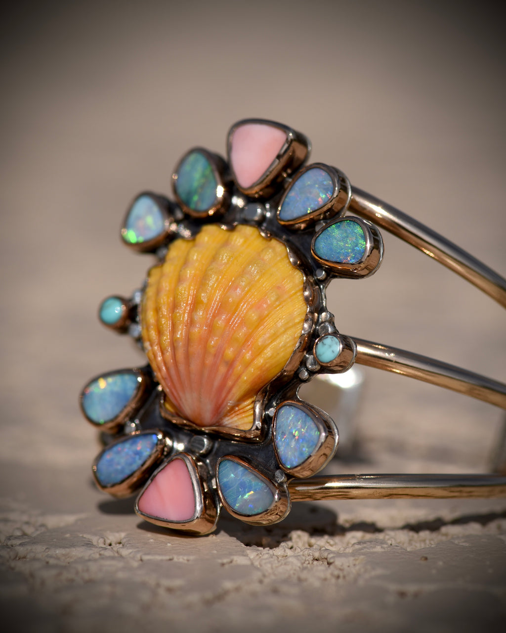 Angled side view of Reef Riot statement cuff showing the layered shell and gemstone settings